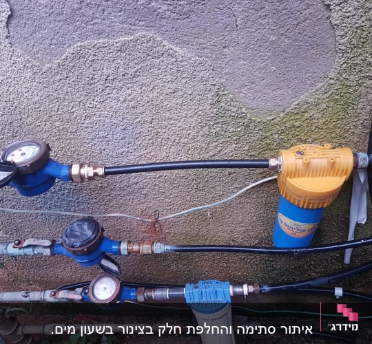 מד מים, צינורות ומסנן מים על קיר